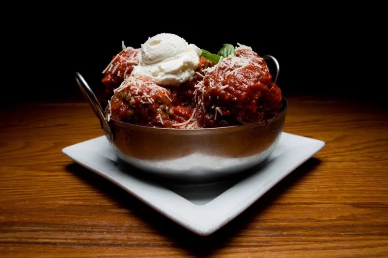 Pot of homemade Sicilian meatballs topped with ricotta